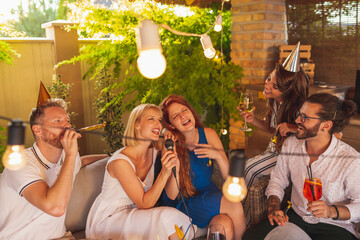 People singing karaoke and drinking cocktails at birthday party