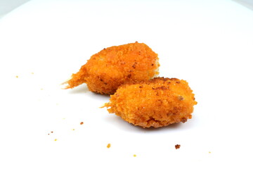 Two fried breaded surimi crab claws, in perspective, isolated on white.