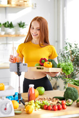 Friendly redhead woman holding natural detox juice in hands