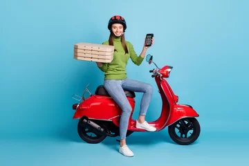Foto op Plexiglas Full length photo portrait of woman holding terminal pizza boxes sitting on red scooter isolated on pastel blue colored background © deagreez