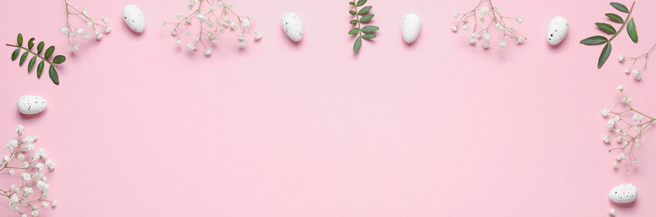 Fototapeta na wymiar Eggs, gypsophila and green twigs on a pink background. Frame. Easter concept