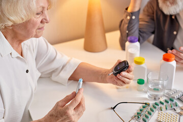 Obraz na płótnie Canvas Close-up Of A Woman's Hand Testing High Blood Sugar With Glucometer
