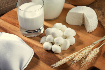 Mozzarella cheese  and milk on wooden stand and spikelets of wheat.Concept for Shavuot holiday.