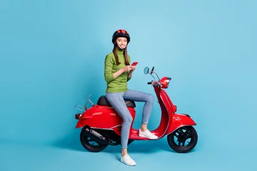 Foto op Plexiglas Full length portrait of charming cheerful girl sitting moped look camera isolated on blue color background © deagreez