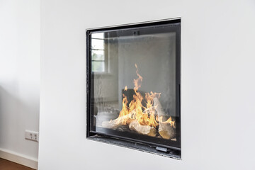 Contemporary fireplace with glass screen installed in white wall in living room at home