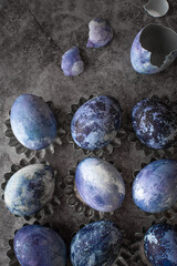 painted marble eggs on a stone background. Easter eggs are painted with natural blueberry dye. Close-up, flat lay