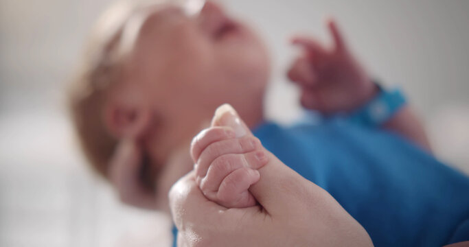 Focus on baby boy tinny hand holding mother finger