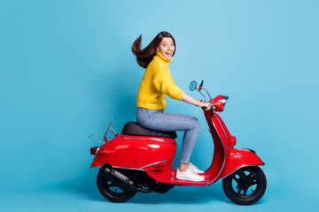 Fototapeta na wymiar Full size profile photo of astonished pretty lady driving moped open mouth smile isolated on blue color background