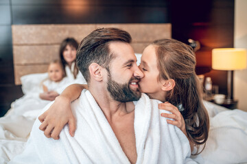 Cute girl hugging her dad, both looking happy