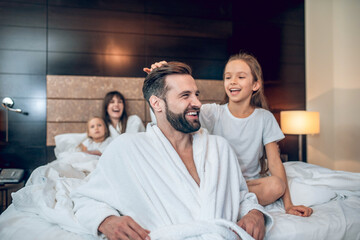 Young bearded man looking happy playing with his daughter