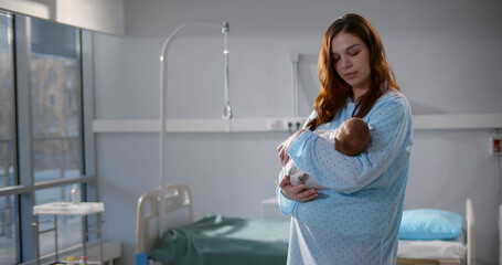 Fototapeta premium Caucasian mother holding her newborn baby after labor in ward at hospital