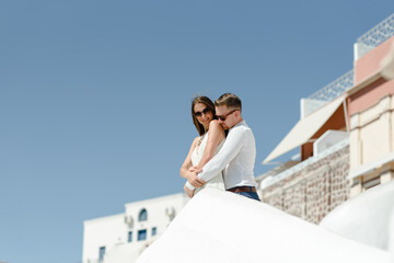Happy couple hugging and laughing together with a view of Santorini
