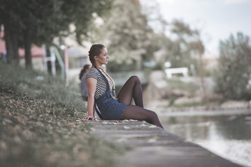 lovely girl sitting on a river