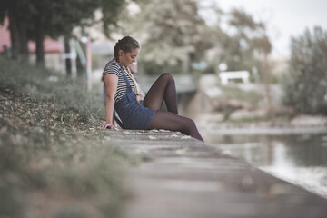 lovely girl sitting on a river