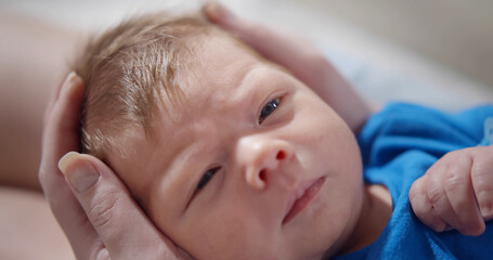 Close up of mother holding cute newborn baby in arms