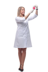 female laboratory assistant looking at the liquid in a laboratory bottle .