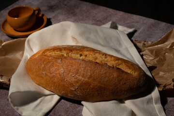 Rico pan recién hecho puesto en un mantel para armar un bodegón armonioso