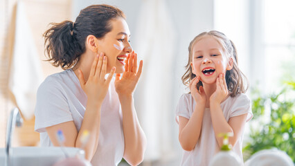 Mother and daughter caring for skin