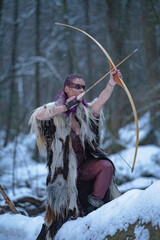 viking girl with a bow in the wood