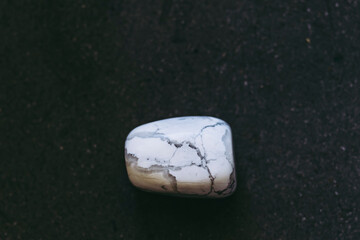 Pierre roulée polie howlite sur un fond noir - Minéral naturel