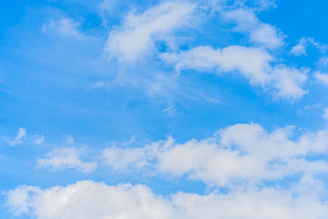 Obraz premium Fluffy white cumulus and cirrus clouds on blue sky in spring