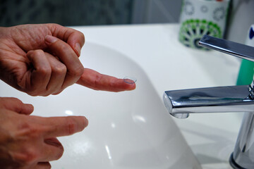 A woman's hands with a contact lens. Vision Correction and Health Care. Contact Lenses.