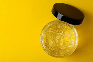 Jar of styling gel on yellow background