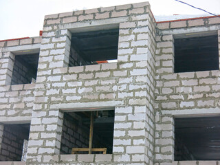 three-story white concrete block house under construction