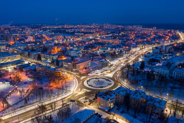 Fototapeta na wymiar Beautiful evening top view of the city. Evening, night illumination in the city. Winter city in the snow.