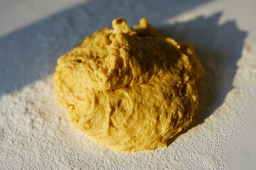Bread dough or cookie baking in kitchen on white table in sunset sunlight. Baking, tasty cookies or Easter pastry making concept. Top view. High quality photo