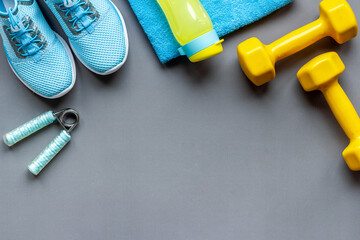 Top view of fitness accessories with dumbbells and sneakers
