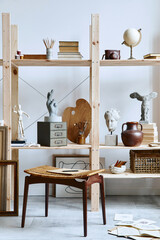 Unique artist workspace interior with stylish stool, wooden bookcase, artworks, painting accessories, decoration and elegant personal stuff. Modern work room for artist. Template.