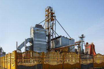 Fototapeta na wymiar Granary elevator. Silver silos on agro-processing and manufacturing plant for processing drying cleaning and storage of agricultural products, flour, cereals and grain.