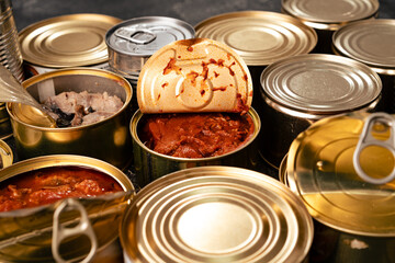 Many cans with conserved fish on wooden table