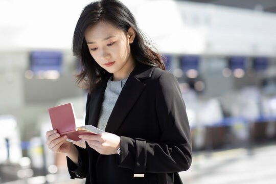 Young businesswoman with airplane ticket at airport