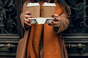 Girl on the street with a disposable paper cup. Take away food, walk around the city.
