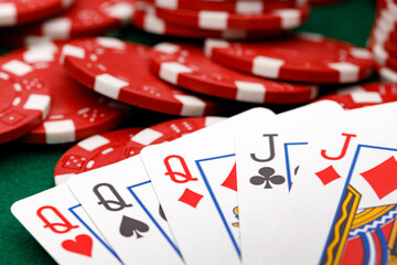 Red playing chips and cards on poker table