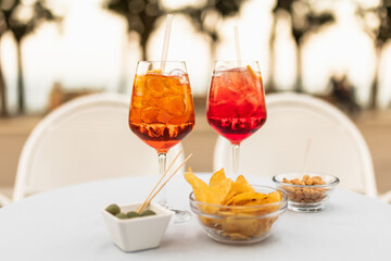 Italian refreshing cocktails with snacks on the table on a summer evening