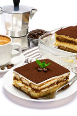 Traditional Italian Tiramisu dessert in glass baking dish, portion on plate and cup of coffee isolated on white background