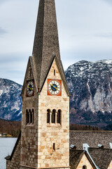 Fototapeta na wymiar Traditional Protestant church and town view of Hallstatt mountain village and see lake against The Austrian Alps. postcard picture in Salzkammergut region, Austria 