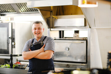 A young male Caucasian chef in the kitchen of the restaurant.