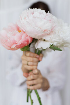 Sensual woman with peony bouquet in hands. Stylish female holding peonies flowers. Bridal morning