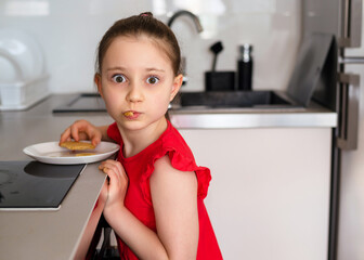 The preschool girl hunts for delicious cookies. Kid girl eats cookies and sweets that are forbidden...