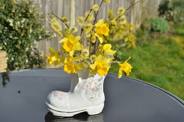 Bouquet of yellow flowers in a boot vase