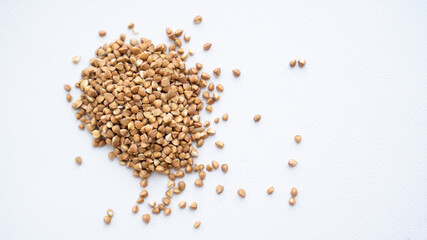 Stack of buckwheat on white background. Top view. A bunch of buckwheat close up. Isolated