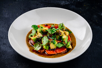 Top view of seared salmon with avocado in bowl, seared salmon salad with sauce at a premium restaurant