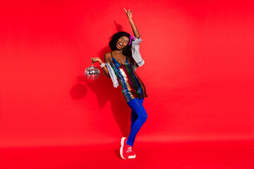 Obraz premium Photo of careless crazy lady hold glowing ball dance raise finger wear glossy dress headband isolated red color background