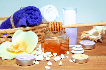 Golden honey jar, orchid flowers, towels and aromatic candles.