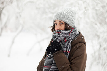 Young woman in warm clothes in winter snowy weather outdoors