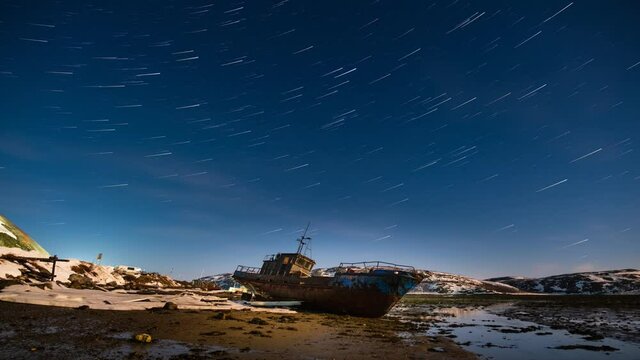Abandoned ship in Arctica inder Moon and stars winter star trails 